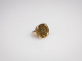 gros plan d'une bague en or sur une surface blanche