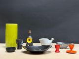 a table with a bowl, cups, and a bottle on it