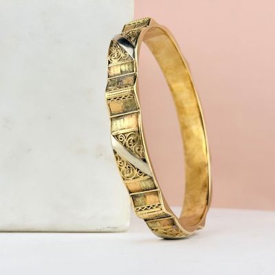 a close up of a gold bang with a black stone in the middle