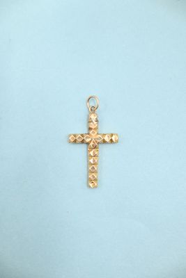 a close up of a gold cross on a blue background