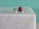 une image représentant une bague ornée d'un rubis posée sur un bloc de marbre blanc