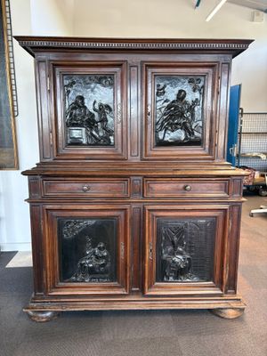 une armoire ancienne en bois, surmontée de panneaux de verre sculptés