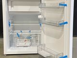 a white refrigerator with its door open on the floor