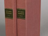 two pink books sitting on top of each other on a gray surface