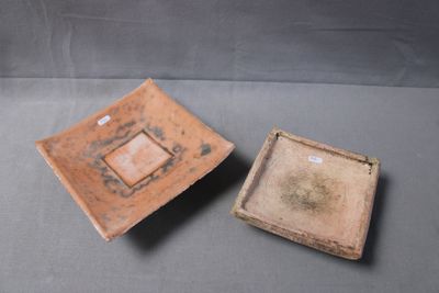 pair of small brown ceramic bowls with square designs on them