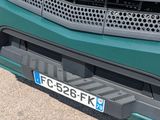 a close up of a green truck with a number plate on it