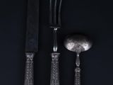 a close up of a knife, fork and spoon on a black background