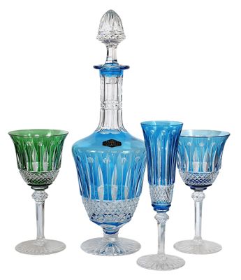 une carafe en verre bleu et des verres à vin posés les uns à côté des autres