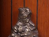 a statue of a bear sitting on top of a wooden shelf