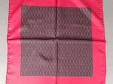 a pink and grey square scarf with a monogram pattern