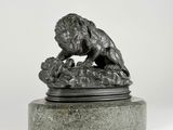 sculpture of a lion on a rock on a marble base