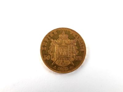 gros plan d'une pièce d'or sur une surface blanche