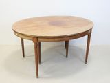 une table ronde avec un plateau en bois posée sur un sol blanc