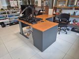 a desk with a computer on it in the middle of a room