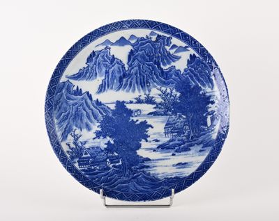 assiette bleue et blanche ornée d'un paysage de montagne