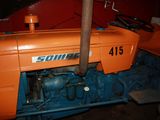 an orange tractor that is parked in a garage