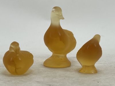 three ducks that are sitting next to each other on a table