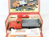 un camion jouet rouge dans une boîte sur laquelle figurent des instructions