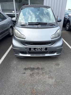 a small silver car parked in a parking lot