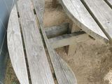 two wooden benches sitting next to each other in the dirt