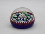 purple and green flower inside a glass ball on a white surface