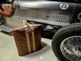 a suitcase sitting next to a vintage car on the floor