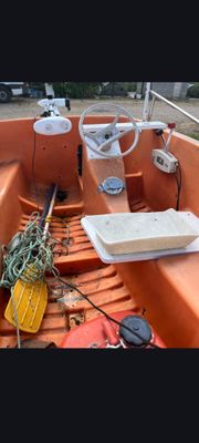 un petit bateau orange rempli de toutes sortes de choses