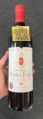 une personne tenant une bouteille de vin sur laquelle figure une étiquette