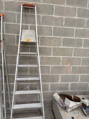 a ladder that is leaning against a wall next to a box