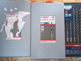 two different types of drill bits in a box on a wooden surface