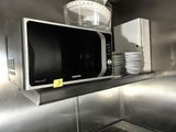un micro-ondes posé sur une étagère dans une cuisine