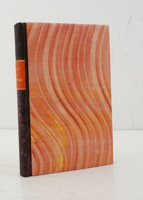 un livre orange et noir posé sur une table blanche