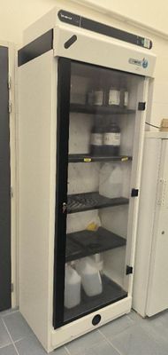 two refrigerators in a room with one open and the other closed
