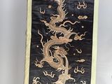 une bannière représentant un dragon noir et doré accrochée au mur