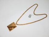 une photo d'un collier en or avec un pendentif carré au bout d'une chaîne
