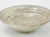 a white and brown bowl on a white surface