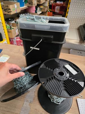 une personne tenant une paire de ciseaux près d'une bobine posée sur une table