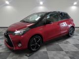 a red toyota yaris parked on a checkered tile floor
