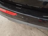 the rear end of a black car with a red tail light