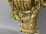 a gold clock on a stand on a white background