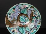 an image of a blue and green plate with flowers on it