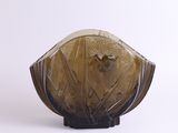 un vase en verre orné d'un oiseau, posé sur une surface blanche
