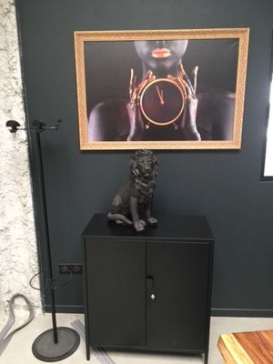 a cat sitting on top of a cabinet in a room