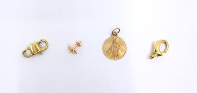 three gold charms and a gold coin on a white surface