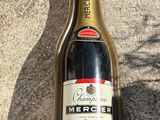 une bouteille de champagne vide posée par terre à côté d'une bouteille de vin