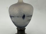 a glass vase with a boat in the water on it