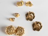 a group of gold jewelry on a white surface