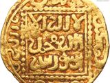 a close up of a gold coin with arabic writing on it