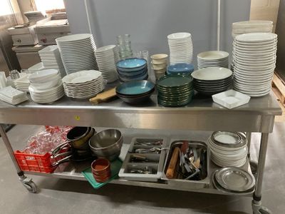 many plates and pans on the table in the kitchen