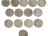 some old silver coins are arranged in a row on a white surface